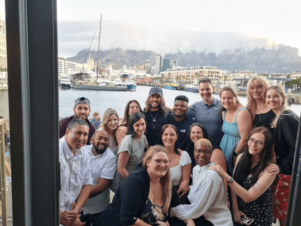 a group of people posing for a picture with a mountain in the background